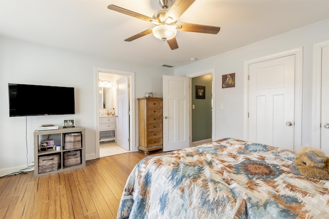 bedroom featuring visible vents, a ceiling fan, ensuite bath, and hardwood / wood-style floors