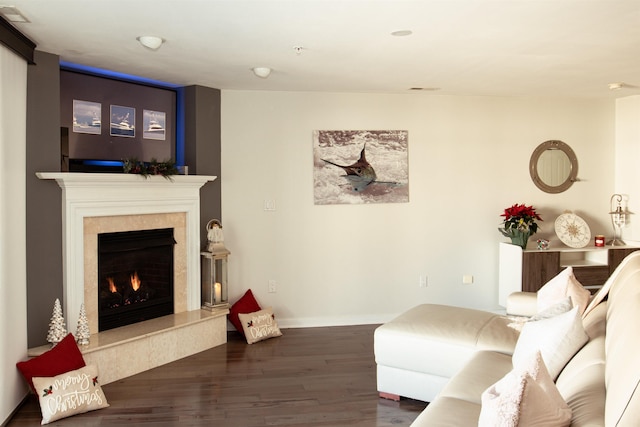 living area with baseboards, dark wood-type flooring, and a high end fireplace