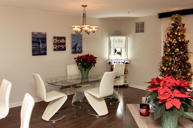 dining room with baseboards, visible vents, a chandelier, and dark wood-style flooring