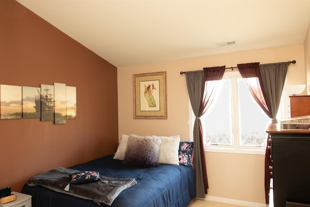 bedroom with lofted ceiling and visible vents