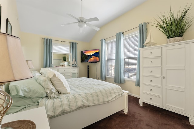 bedroom with ceiling fan, dark carpet, and vaulted ceiling