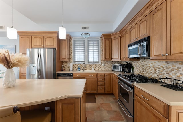 kitchen featuring hanging light fixtures, decorative backsplash, sink, and stainless steel appliances