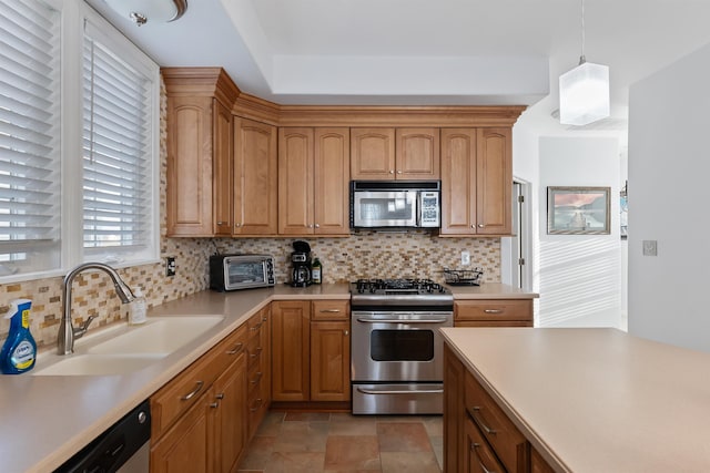 kitchen featuring decorative backsplash, sink, hanging light fixtures, and appliances with stainless steel finishes