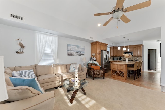 tiled living room with ceiling fan and vaulted ceiling