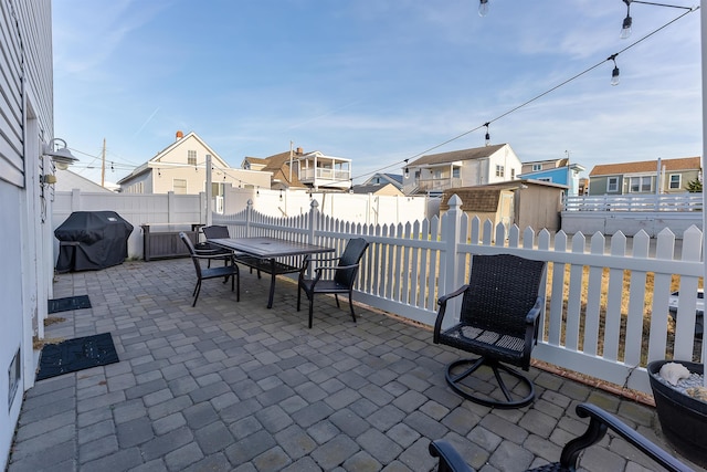 view of patio / terrace with a shed and a grill