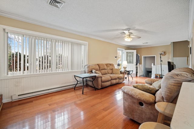 38 Stanhope Rd, Marmora, NJ 08223 - living room with wood-type flooring, a baseboard heating unit, a textured ceiling, and ornamental molding