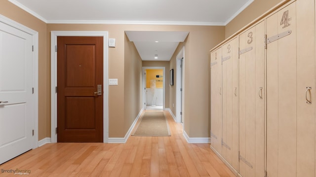 corridor featuring baseboards, ornamental molding, and light wood-style floors