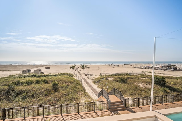 water view with fence and a view of the beach