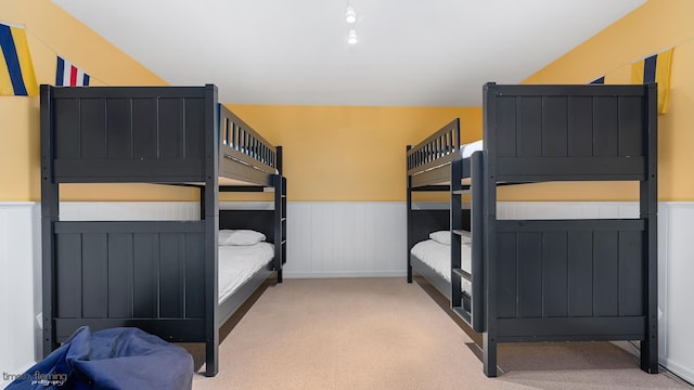 bedroom featuring a wainscoted wall and carpet