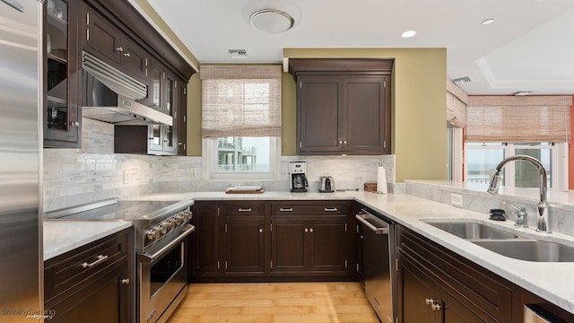 kitchen with light countertops, premium appliances, a sink, and visible vents