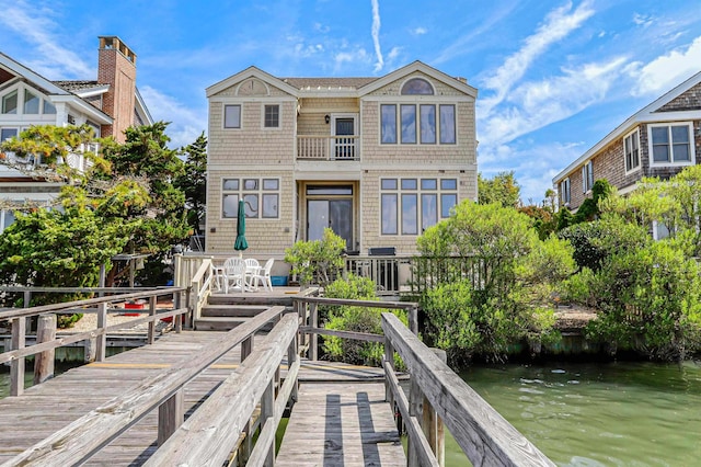 rear view of property featuring a water view and a balcony