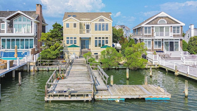 rear view of property featuring a water view and a balcony