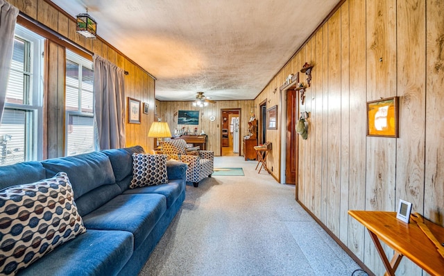 living room with light carpet, ceiling fan, and wood walls