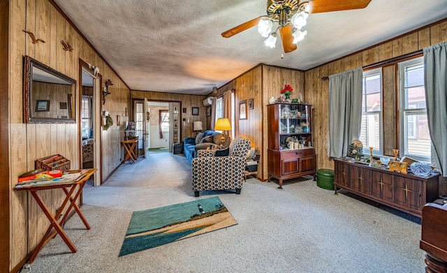 living room with ceiling fan, light colored carpet, and wooden walls