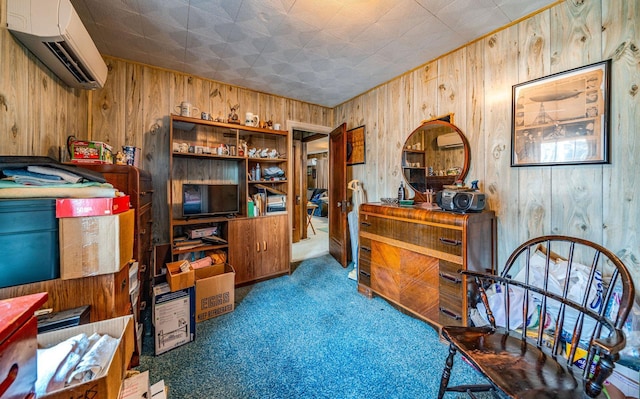 sitting room with wooden walls, carpet flooring, and an AC wall unit