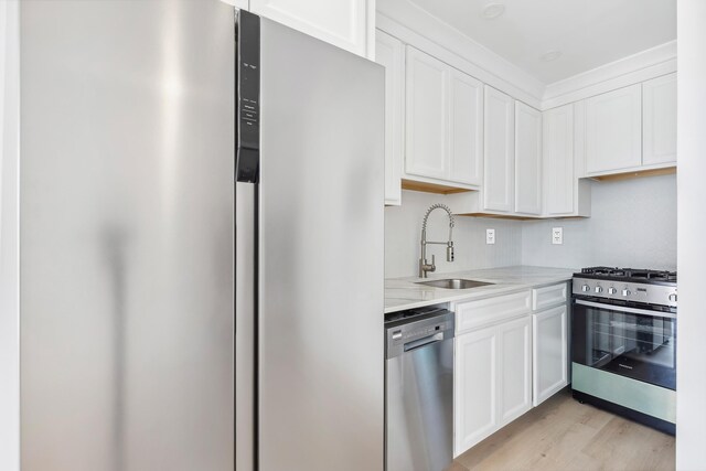 233 E Juniper Ave Unit A, Wildwood, NJ 08260 - kitchen featuring appliances with stainless steel finishes, a sink, light countertops, white cabinets, and light wood-style floors