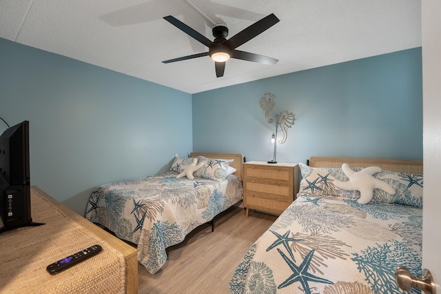 bedroom featuring hardwood / wood-style flooring, a textured ceiling, and ceiling fan