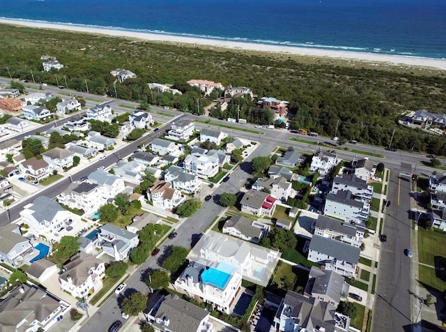 bird's eye view featuring a water view and a beach view