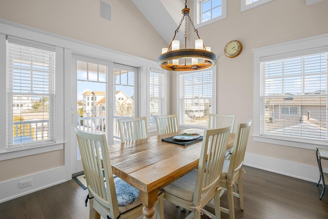 dining room featuring an inviting chandelier, plenty of natural light, dark hardwood / wood-style flooring, and vaulted ceiling