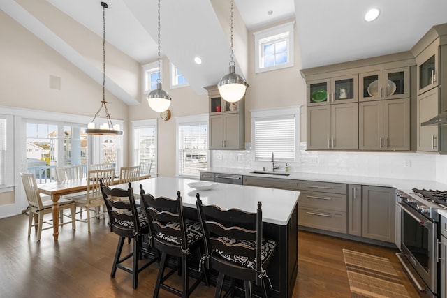 kitchen with a kitchen island, decorative light fixtures, sink, stainless steel appliances, and dark wood-type flooring