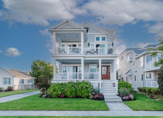 view of front facade with a front yard, a balcony, and a porch