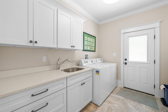 laundry area featuring cabinets, crown molding, washer and dryer, and sink