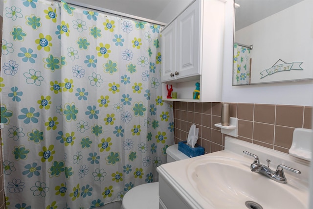 bathroom featuring curtained shower, vanity, tile walls, and toilet