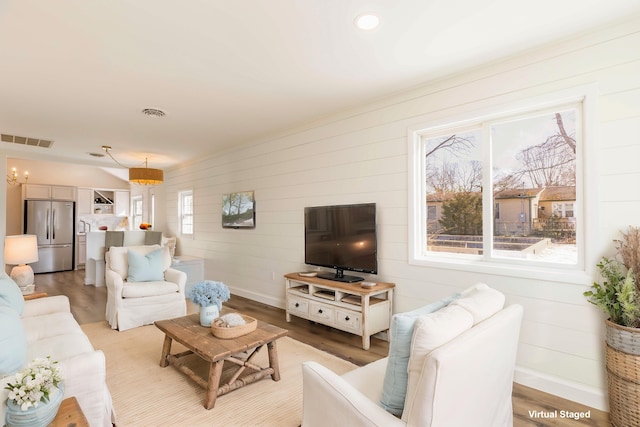 living room with an inviting chandelier and light wood-type flooring