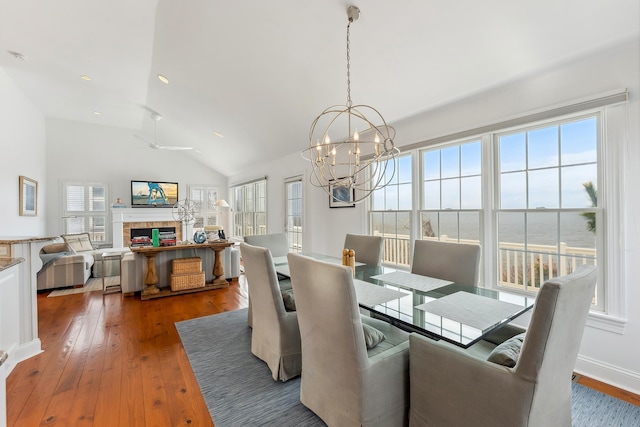 3005 Shore Dr, Cape May Beach, NJ 08251 - dining room featuring baseboards, a tiled fireplace, recessed lighting, vaulted ceiling, and hardwood / wood-style floors