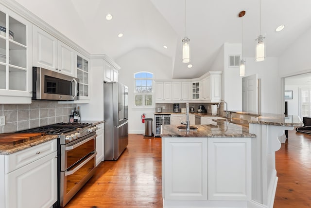 3005 Shore Dr, Cape May Beach, NJ 08251 - kitchen with vaulted ceiling, appliances with stainless steel finishes, a sink, beverage cooler, and light wood finished floors