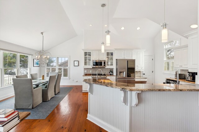3005 Shore Dr, Cape May Beach, NJ 08251 - kitchen featuring glass insert cabinets, an inviting chandelier, dark wood-style flooring, stainless steel appliances, and backsplash