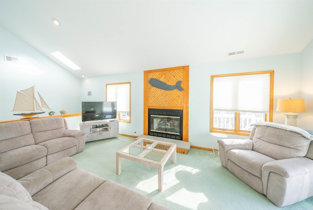 living room with vaulted ceiling with skylight, light carpet, and a healthy amount of sunlight