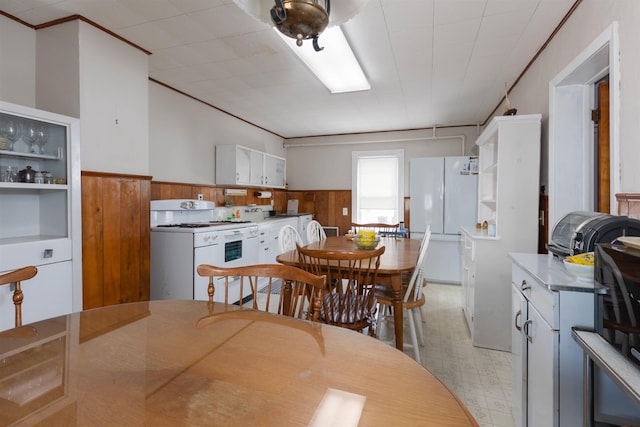 112 E Montgomery Ave, Wildwood, NJ 08260 - dining space with wood walls, a wainscoted wall, washer / dryer, light floors, and ornamental molding