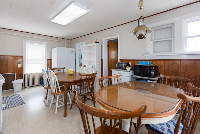 112 E Montgomery Ave, Wildwood, NJ 08260 - dining room featuring wood walls, wainscoting, radiator, and light floors