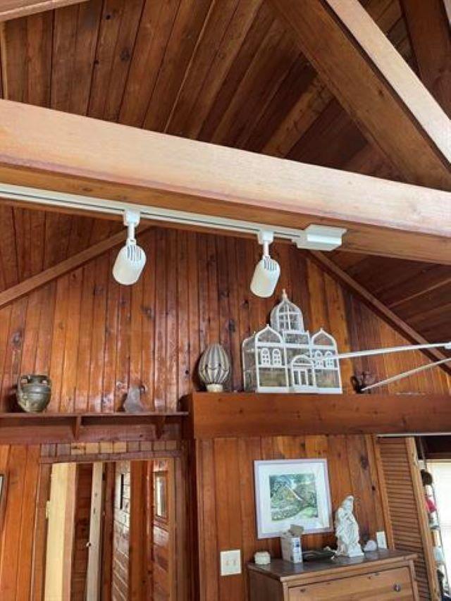 room details featuring wooden ceiling, beamed ceiling, and wood walls
