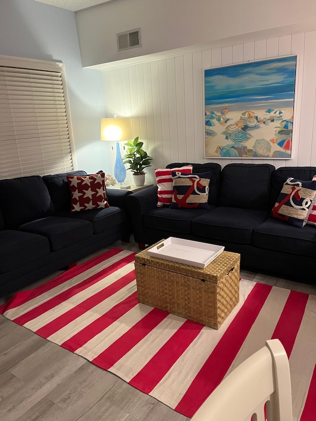 living room with wood walls and light hardwood / wood-style flooring