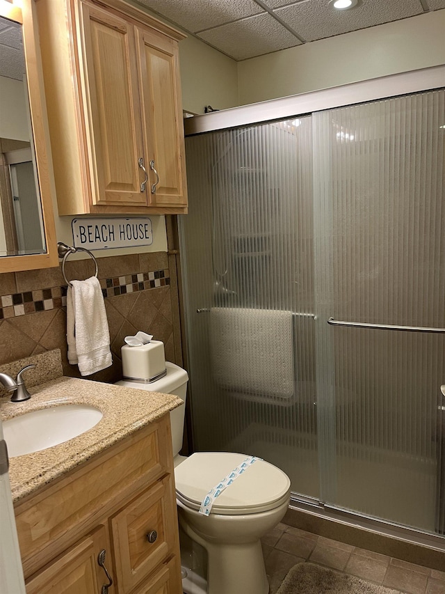 bathroom featuring vanity, toilet, an enclosed shower, and tile walls