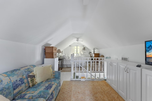 interior space featuring a ceiling fan, vaulted ceiling, and visible vents