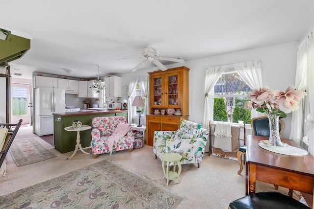 living room featuring a healthy amount of sunlight, light carpet, a ceiling fan, and visible vents