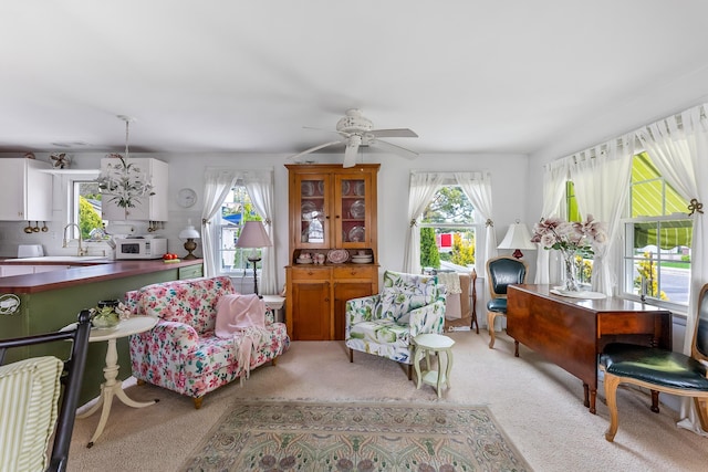 living area with ceiling fan, light carpet, and a wealth of natural light