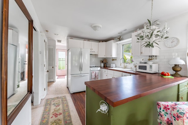 kitchen with a sink, tasteful backsplash, white appliances, and a wealth of natural light