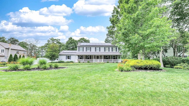 13 Mooring Cir, Seaville, NJ 08230 - view of front of property featuring covered porch, a standing seam roof, a front yard, and solar panels