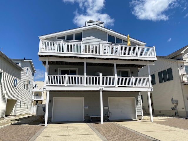 25 81st St W, Unit West, Sea Isle City, NJ 08243 - coastal inspired home with concrete driveway, an attached garage, a chimney, and a balcony