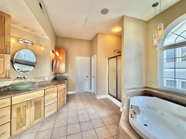 bathroom with tile patterned floors, vanity, and shower with separate bathtub