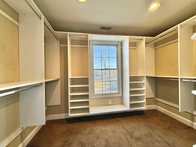 walk in closet featuring dark carpet