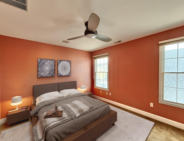 bedroom with multiple windows, ceiling fan, and carpet floors