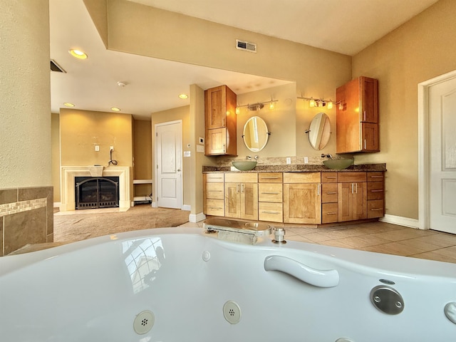 bathroom featuring a bathtub, vanity, and tile patterned flooring