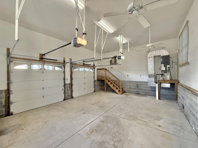 garage featuring heating unit, ceiling fan, and a garage door opener