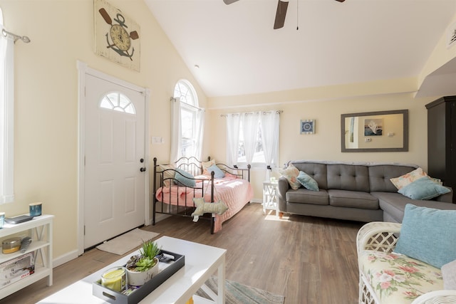 living room featuring a ceiling fan, baseboards, high vaulted ceiling, and light wood finished floors