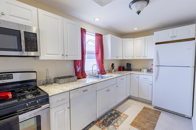 kitchen with appliances with stainless steel finishes, a sink, and white cabinetry